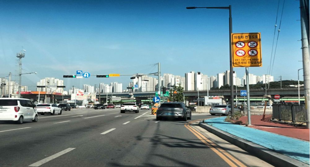 Entrance to a motorway on the right · Road with four lanes in each direction · Right-turn-only lane present · Vehicle signal ahead is green