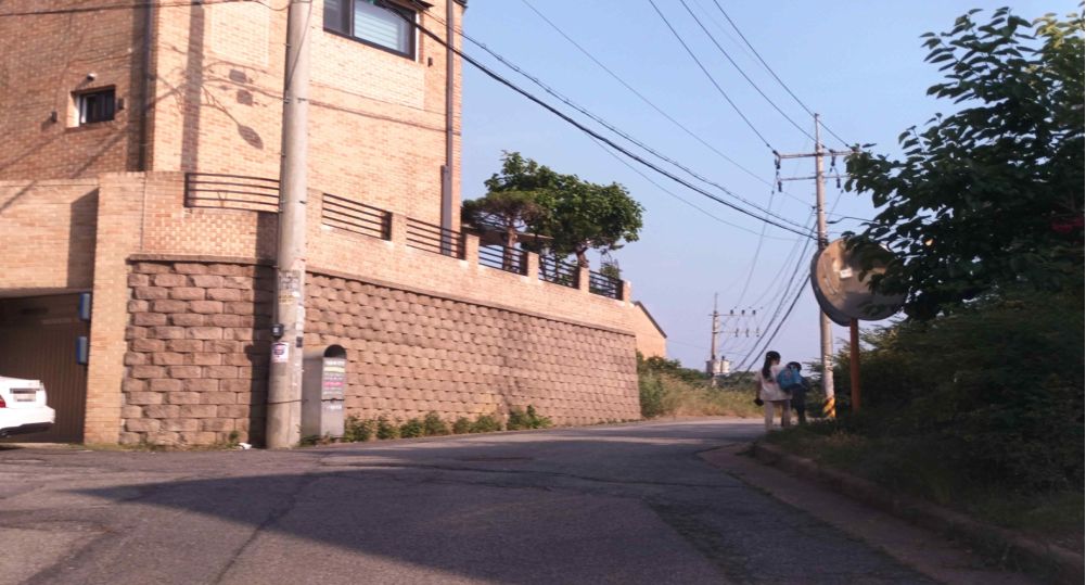 Uphill road curving right with no center line · Alley on the left