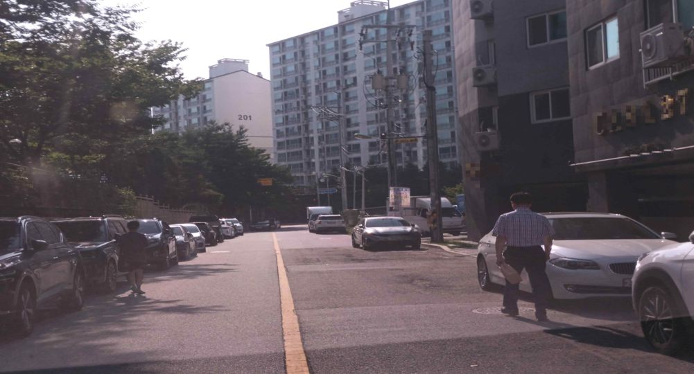 Residential road with one lane in each direction · Vehicles parked on both sides of the road