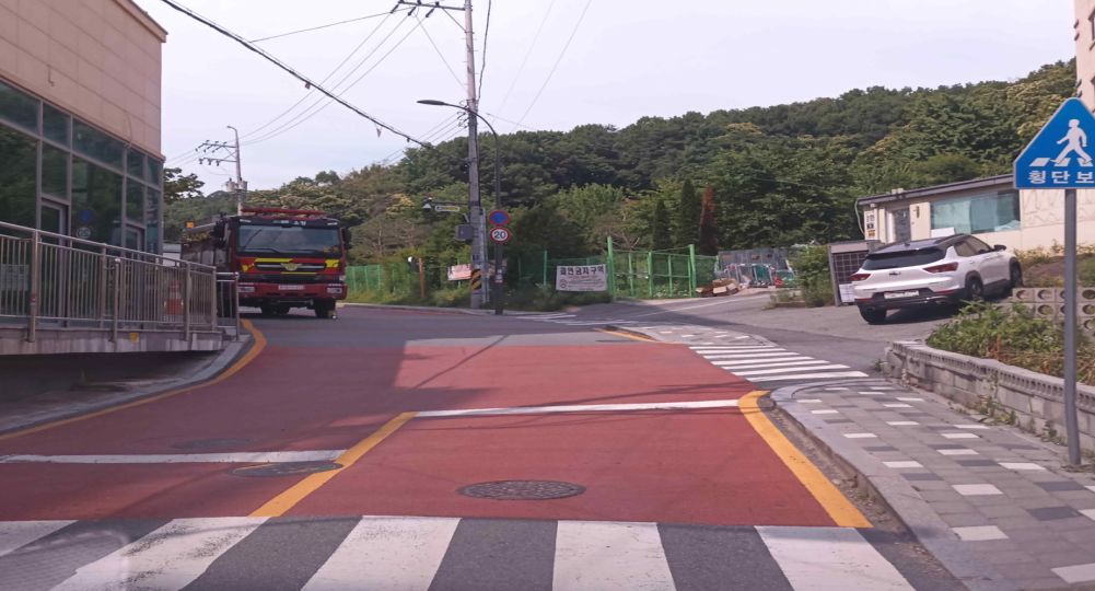 Child protection zone · Crosswalk without traffic signals · Intersection leading to an alley on the right · Fire truck parked with wheel chocks · Uphill road curving to the left, one lane in each direction