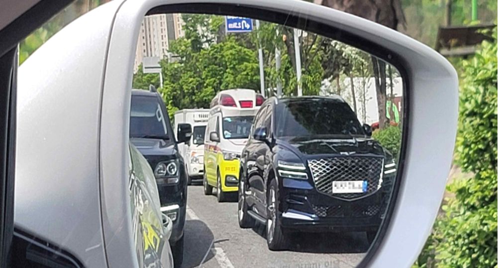 Road with two lanes in each direction · Emergency vehicle on a call spotted in lane 2 in the right side mirror · Heavy traffic causing congestion