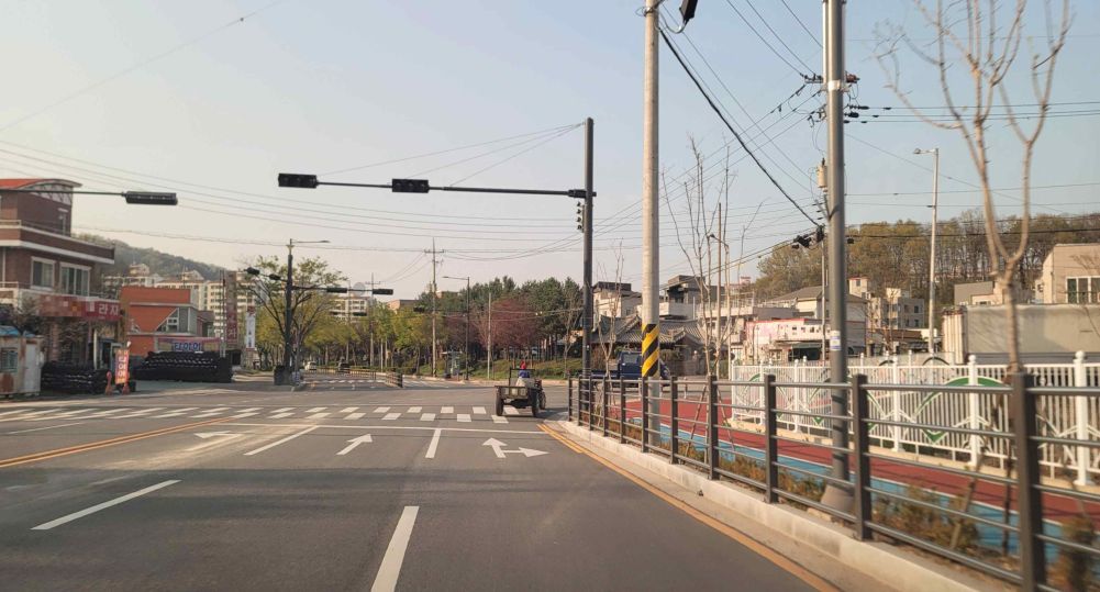 ถนนทางเดียวละ 3 ช่องทาง · ทางแยกที่สัญญาณไฟไม่ทำงาน · รถไถเดินตามกำลังวิ่งอยู่ข้างหน้า