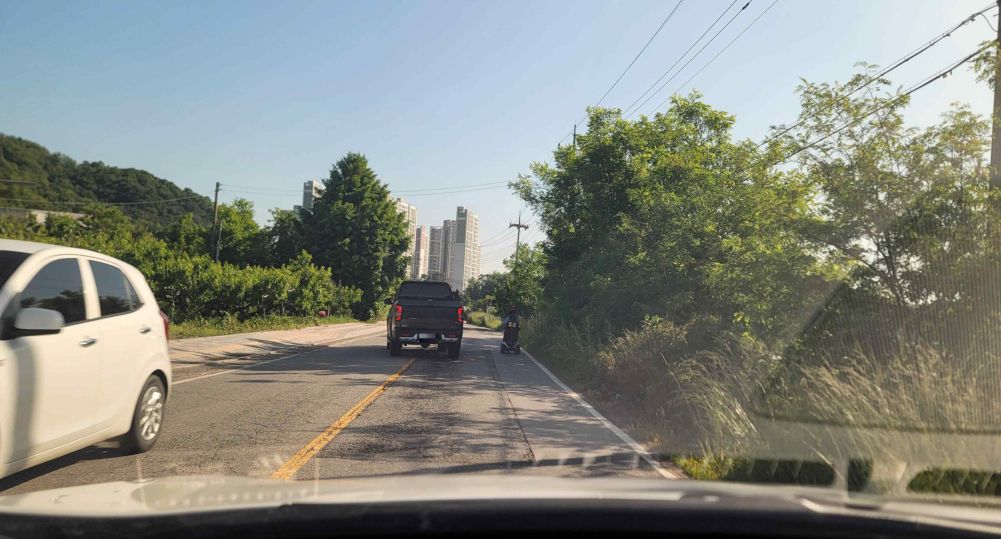 Road with one lane in each direction · Walking-aid wheelchair moving ahead on the right · Truck ahead overtaking