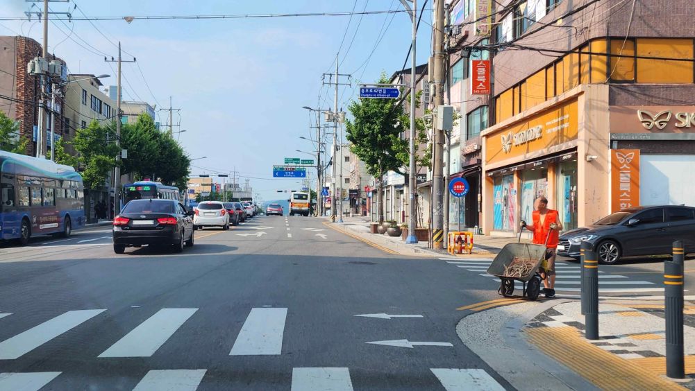 ทางม้าลายที่ไม่มีสัญญาณไฟ · สี่แยก · มีคนเดินเท้ารอข้ามทางม้าลายอยู่ที่มุมขวาของทางแยก