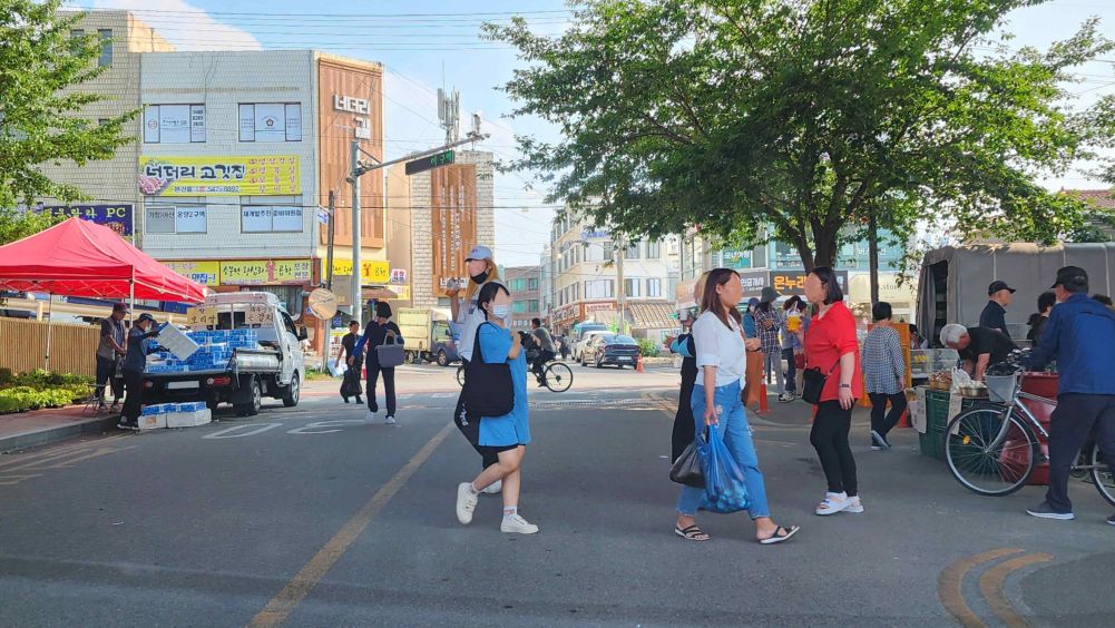 Road with a sidewalk, roadway and center line · Many pedestrians crossing the road