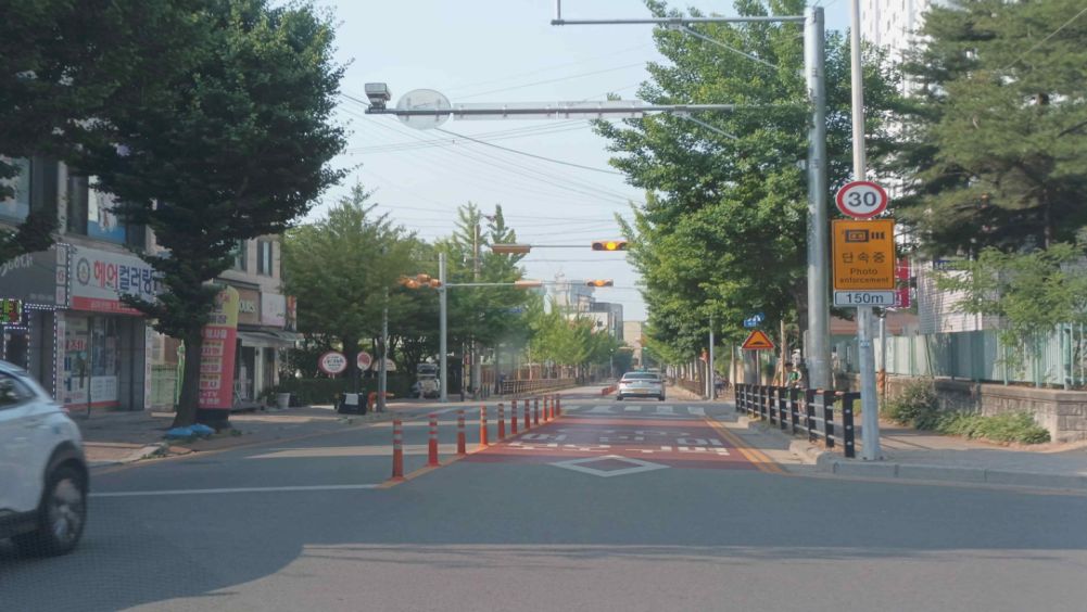 Children's protection zone · Pedestrians waiting at the crosswalk · Pedestrian guard fence installed along the sidewalk · Vehicle light has changed from green to yellow