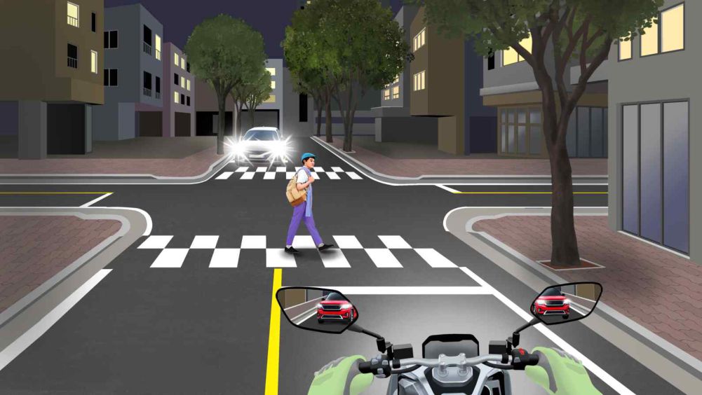 A crosswalk with a pedestrian crossing at night · Oncoming vehicles are driving with headlights on · A vehicle approaching from behind is visible in the mirror